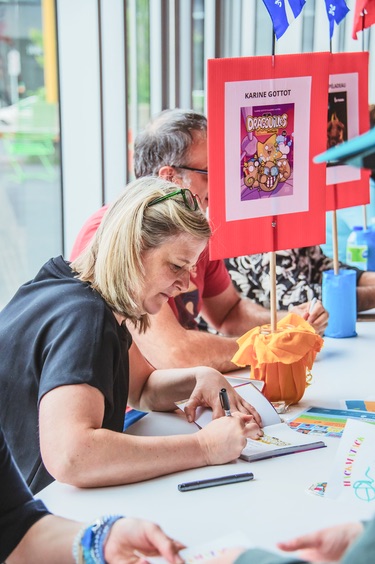 L'auteure Karine Gottot signe des autographes.